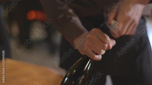 Close up, waiter opens wine bottle