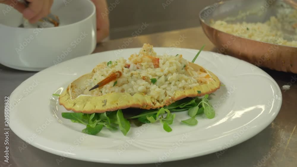 Close up, chef places crab leg on risotto Close up, chef places crab leg on risotto