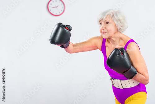 Φωτογραφία sportive senior lady boxing and looking away