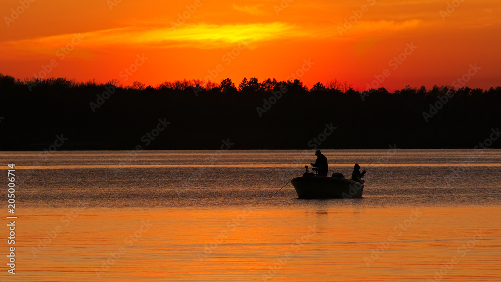 Silhouette of father and son fishing on Lake Irving at sunset in Bemidji, Minnesota.