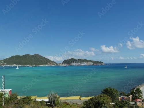 Beatiful green and blue bay in Philipsburg  with a cruise ship docked at the port in the distance. 