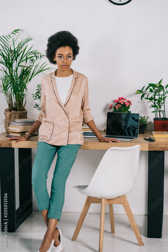 attractive african american businesswoman leaning on table in office attractive african american businesswoman leaning on table in office
