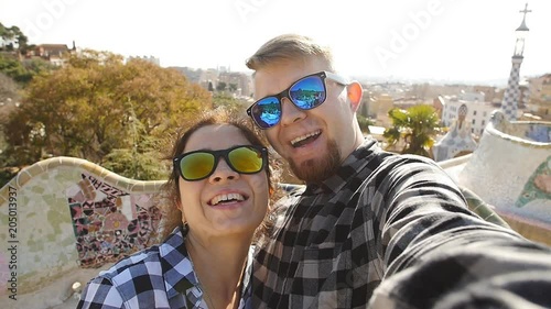 Travel couple happy talking selfie self-portrait with smartphone in Park Guell, Barcelona, Spain