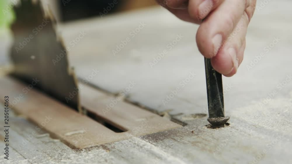 Senior man sets up woodworking equipment with screwdriver for further work Senior man sets up woodworking equipment with screwdriver for further work