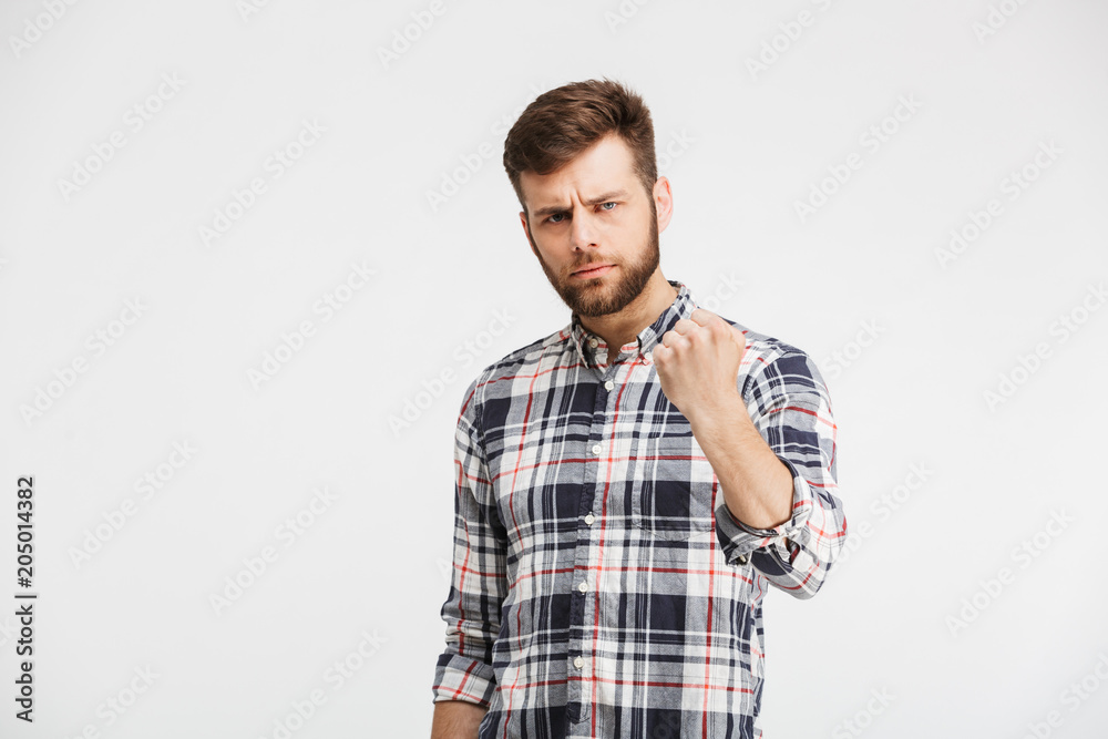 Portrait of an angry young man threatening with a fist Portrait of an angry young man threatening with a fist
