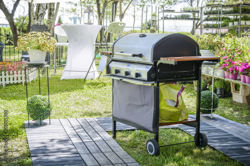 barbecue in the garden with flower and decking. gas barbecue.