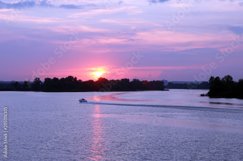 a motor boat sails on the river at sunset of the day