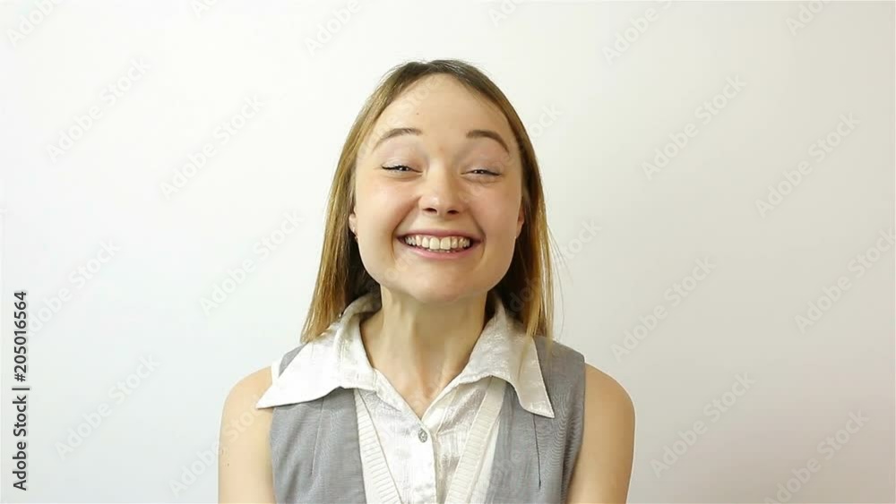Happy young woman welcomes and smiles. Online video chat on a gray background Happy young woman welcomes and smiles. Online video chat on a gray background