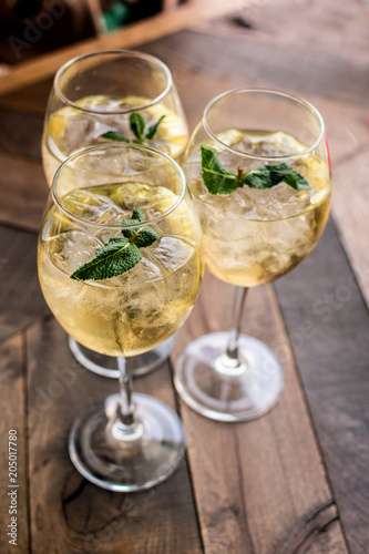 Florence, Tuscany / Italy. - May 14, 2018. A glass of white wine in a large glass with ice and mint leaves in a bar in Florence, aperitif time