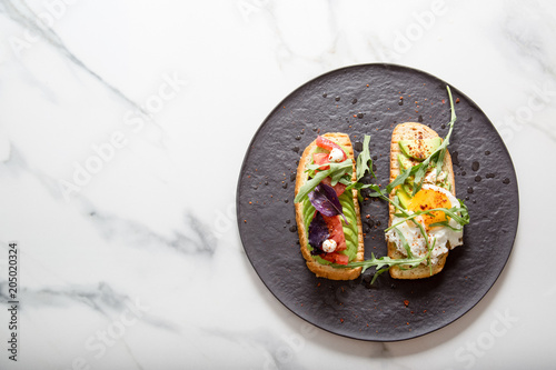 Toast with veggies,avocado, arugula, basil, tomato, mozzarella cheese  and sunny side up egg
