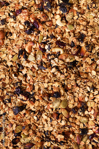 Organic homemade roasted granola with nuts and rasins on baking sheet. Food for breakfast. Meal background  granola texture