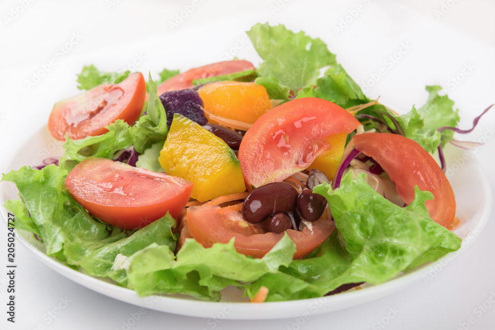 Vegetable salad on white plate isolated on white background. Vegetable salad on white plate isolated on white background.