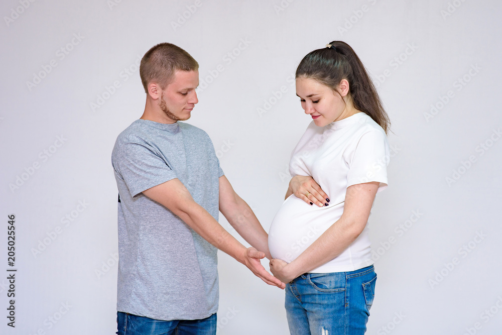 husband and pregnant wife communicate in studio on white background husband and pregnant wife communicate in studio on white background