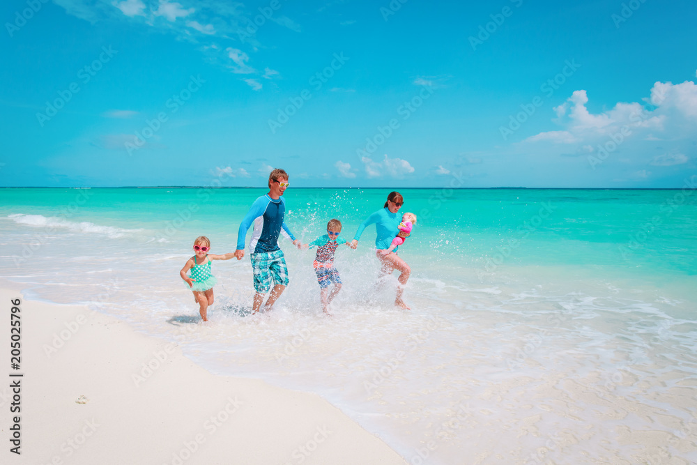 happy family with kids play with water run on beach happy family with kids play with water run on beach