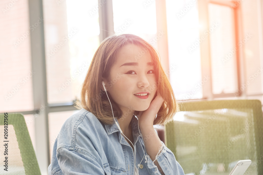 Young woman using mobile phone with earphone Young woman using mobile phone with earphone