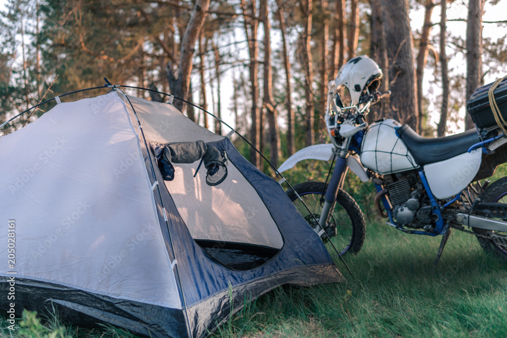 Camping in forest, motorcycle touring, dual sport enduro, tent and off road adventure motorcycle, active style concept Stock Photo | Adobe Stock