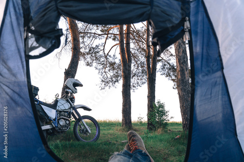 outside my tent view, first person. Camping in forest, motorcycle touring, dual sport enduro, tent and off road adventure motorcycle, active life style concept