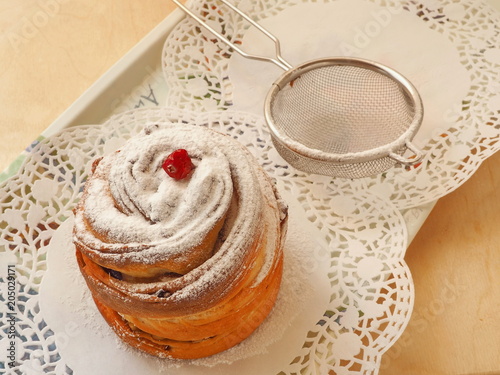 Decorating homemade dessert with sugar powder and dried berries. Cruffin dessert. Selective focus. Vintage toned.