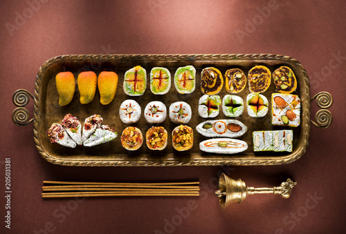 Indian sweets and Mithai in a tray, incense and bell for Diwali festival, flat lay, top view photo