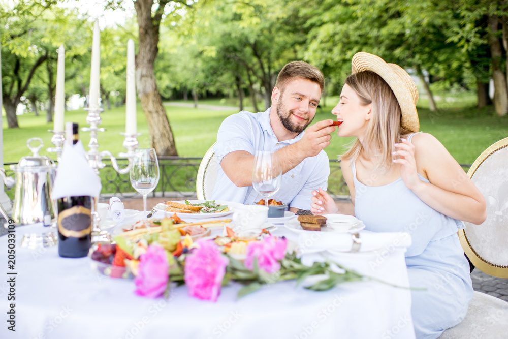 Young couple having romantic breakfast outdoors