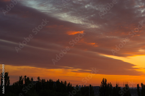 Landscape with dramatic light - beautiful golden sunset with saturated sky and clouds.