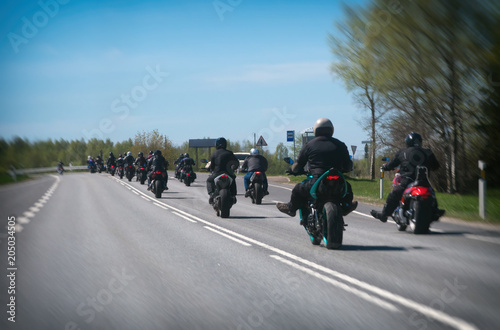 Column of bikers riding on the road. photo