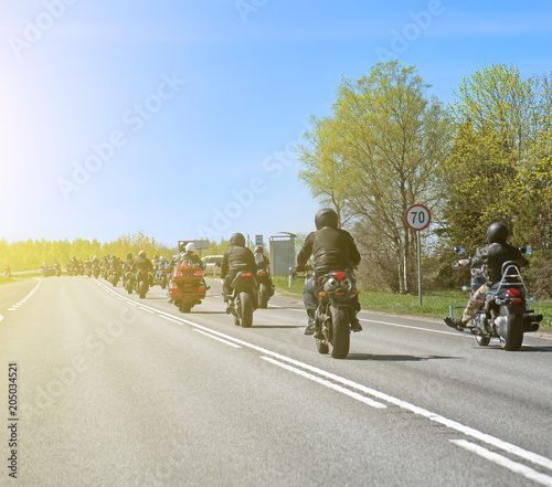 Column of bikers riding on the road.