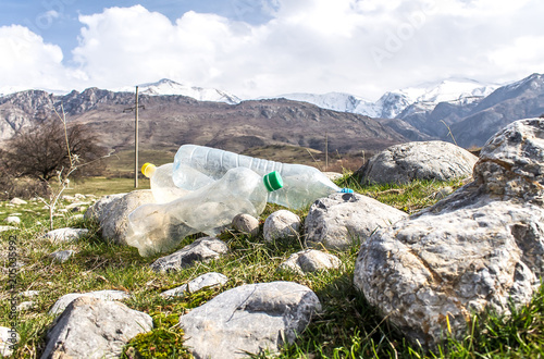 Obraz na plátně Old plastic bottles on the background of the mountains pollution