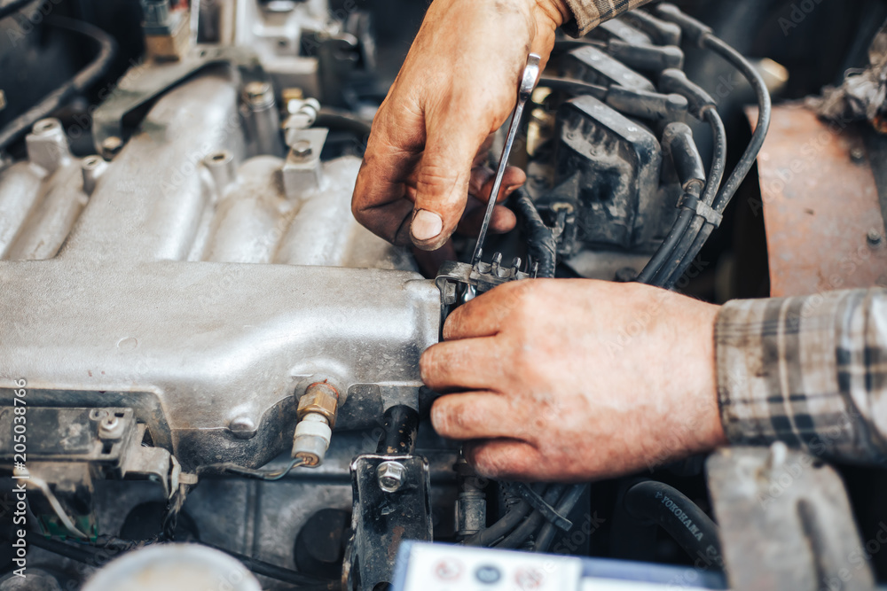 dirty hands of auto mechanic reparing car