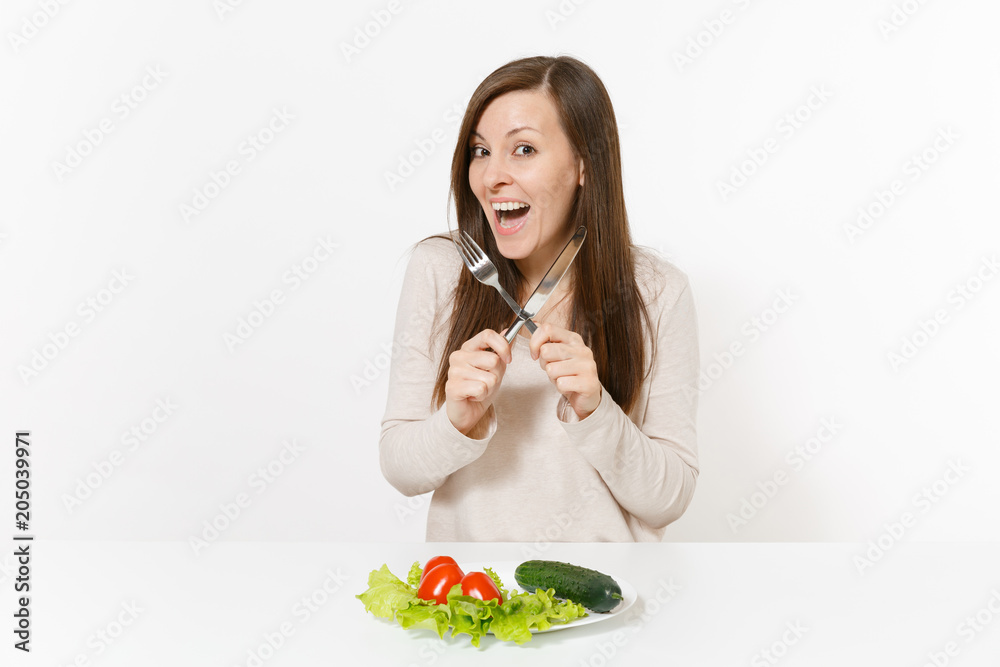 Vegan woman at table with leaves salad lettuce, vegetables on plate isolated on white background. Proper nutrition, vegetarian food, healthy lifestyle dieting concept. Advertising area with copy space Vegan woman at table with leaves salad lettuce, vegetables on plate isolated on white background. Proper nutrition, vegetarian food, healthy lifestyle dieting concept. Advertising area with copy space