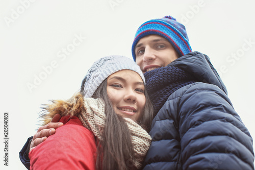 Cute couple in warm clothes on white background