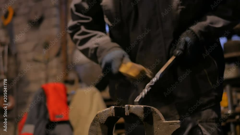 Professional blacksmith working with metal at forge, workshop. Handmade, craftsmanship and blacksmithing concept Professional blacksmith working with metal at forge, workshop. Handmade, craftsmanship and blacksmithing concept