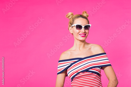 travel, vacation, summer holidays concept - portrait of happy young woman in sunglasses on pink background with copyspace © satura_