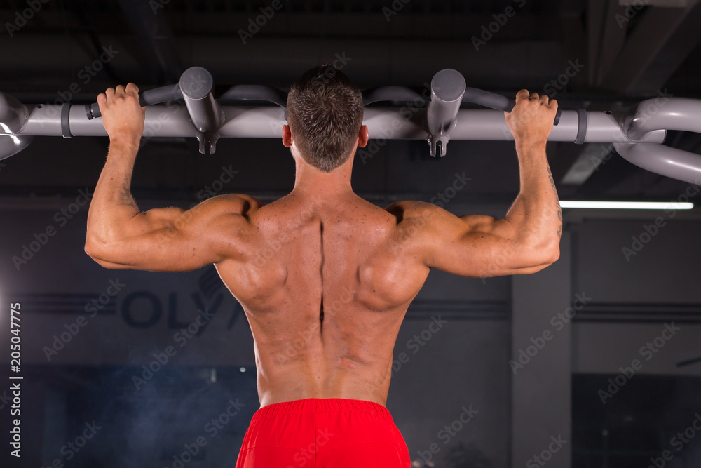 Handsome Muscular Man With Perfect Body Doing Pull Ups in gym Handsome Muscular Man With Perfect Body Doing Pull Ups in gym