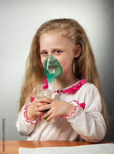 Girl performs physiotherapy-inhalation, in the hands of nebulizer