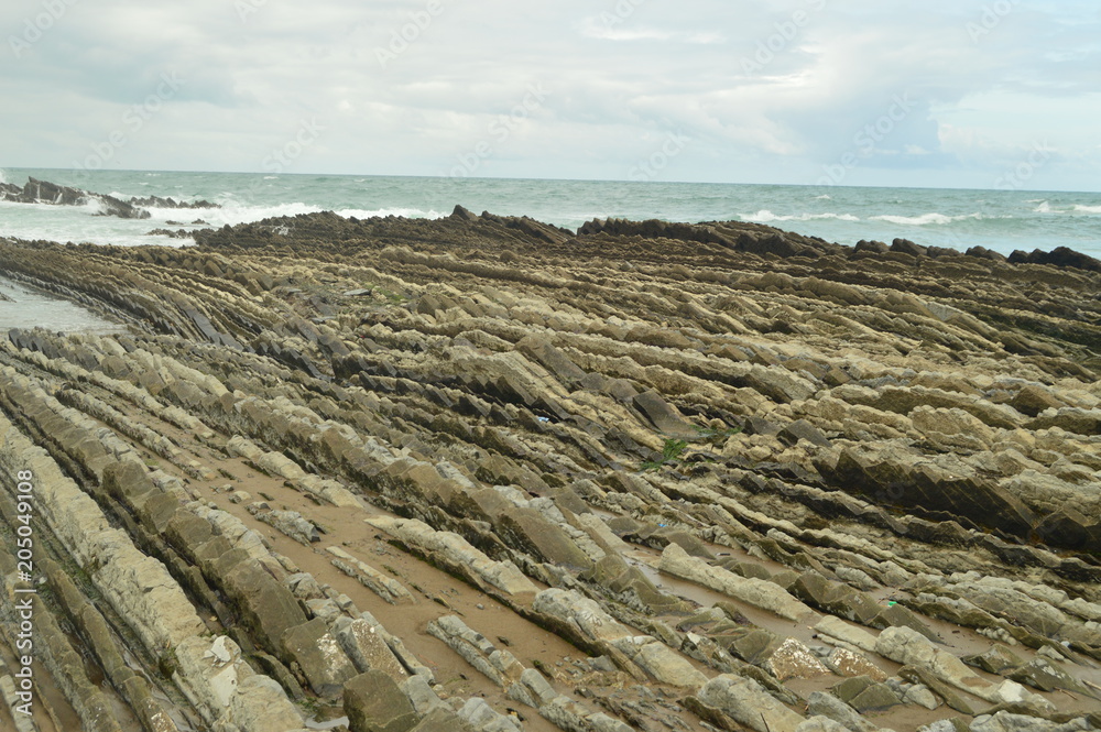 Geological Formations On The Beach With Finish On The Sea Of The Flysch Type Geopark Basque Route UNESCO. Filmed Game Of Thrones. Itzurun Beach. Geology Landscapes Travel. Zumaia Guipouzcoa Spain Geological Formations On The Beach With Finish On The Sea Of The Flysch Type Geopark Basque Route UNESCO. Filmed Game Of Thrones. Itzurun Beach. Geology Landscapes Travel. Zumaia Guipouzcoa Spain