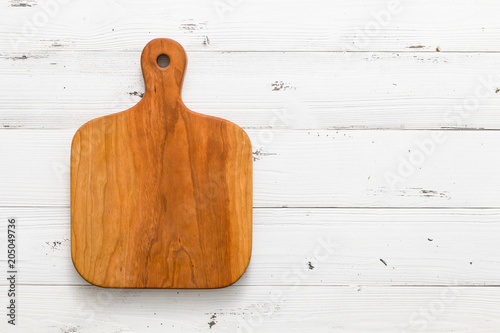 Photo Handmade cherry wooden chopping board on a white wooden board desktop