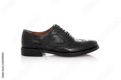 Close up of a black mens brogues shoes on white background with reflection. Fashion advertising shoes photos.