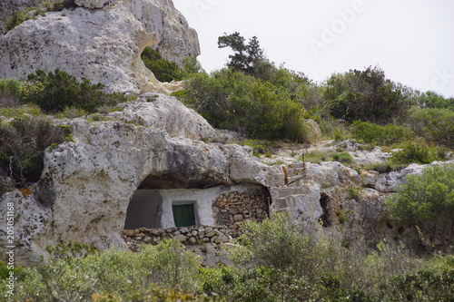 Fotografie Maison troglodyte en pierre sous un rocher dans la campagne de l'île de Minorque aux Baléares, Espagne