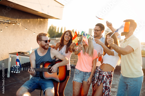 Group of happy friends having party on rooftop © NDABCREATIVITY