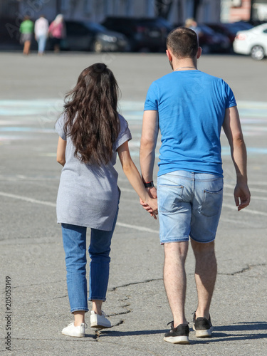 A man and a girl are walking by the hand