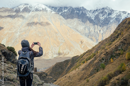 beautiful girl takes pictures of mountains in Georgia