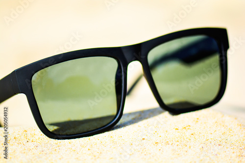 Fashion sunglasses on sea beach. Summer holiday relax background