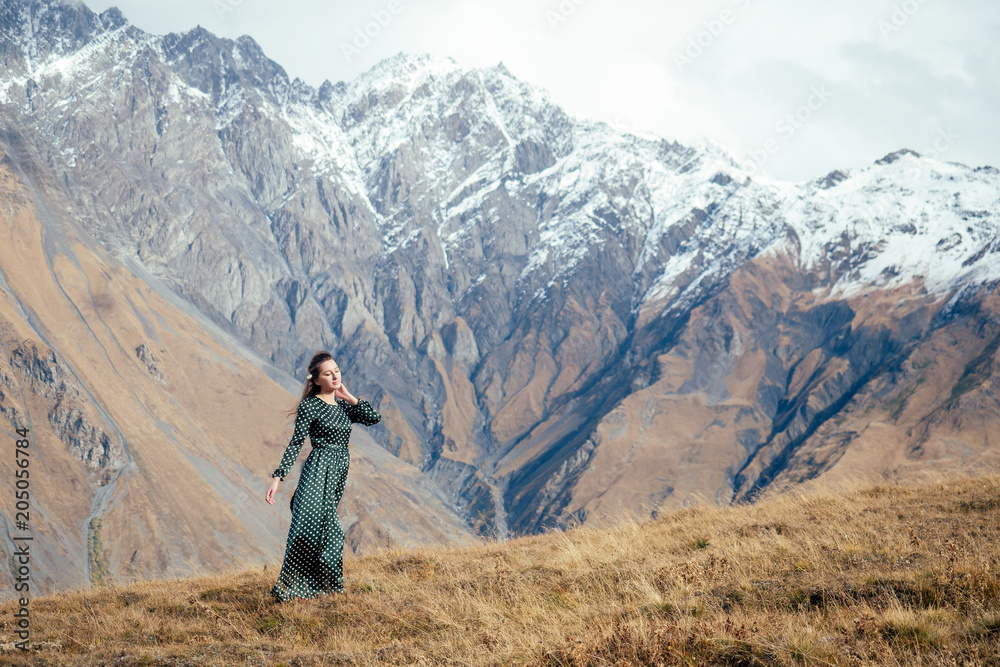 young girl in a beautiful dress in the mountains