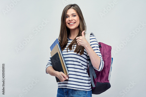 Student woman showint thumb up, holding notebooks.
