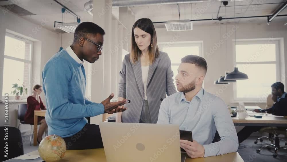 Serious female executive helping young multiethnic workers. Woman manager motivates troubled employees in office 4K. Serious female executive helping young multiethnic workers. Woman manager motivates troubled employees in office 4K.