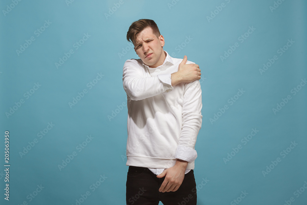 Young man overwhelmed with a pain in the shoulder Young man overwhelmed with a pain in the shoulder