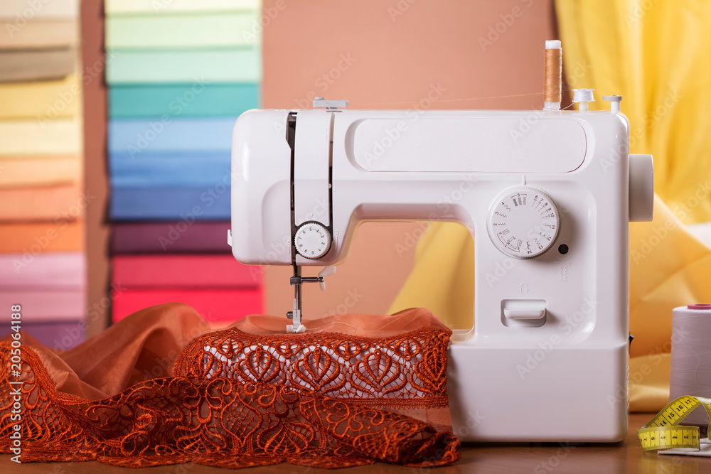Household sewing electric machine in operation, behind fabric samples