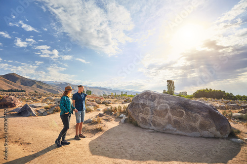Couple of tourist near ancient stone painting