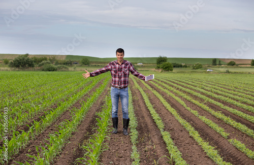 Farmer with tablet on field in spring